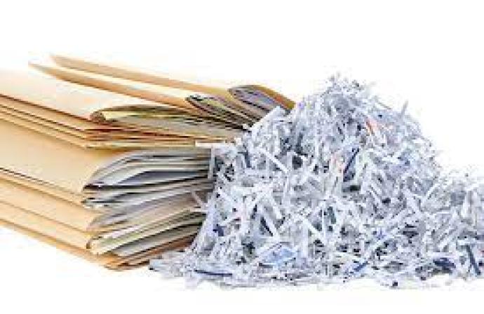 Stack of files next to shredded paper